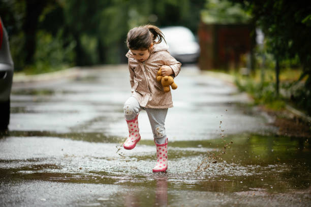 행복한 어린 소녀 점프 에 이 비 스톡 사진 - puddle rain child splashing 뉴스 사진 이미지