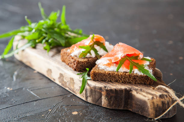 istock cheese, red fish and arugula sandwich on a board, selective focus, copy space 1251677771