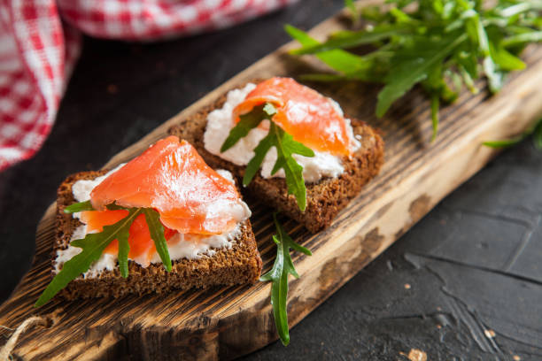 istock cheese, red fish and arugula sandwich on a board, selective focus, copy space 1251677775