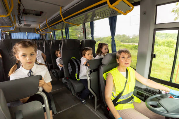 istock Female bus driver looking in the back mirror 1251680145