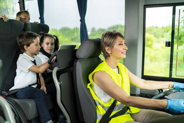 istock Female bus driver driving the schoolboy, looking forward. 1251680170