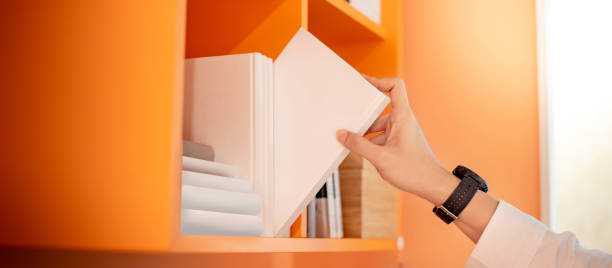 istock Male hand picking white book on bookshelf 1251682502