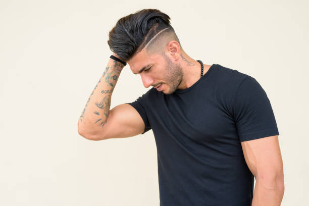 profile view of young handsome bearded persian man looking down - stubble men tattoo sensuality imagens e fotografias de stock