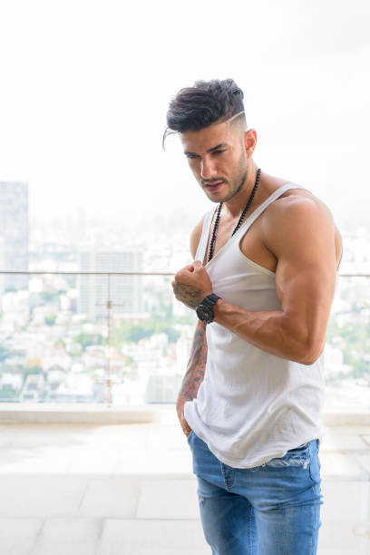 joven guapo barbudo hombre persa en la ciudad al aire libre - stubble men tattoo sensuality fotografías e imágenes de stock