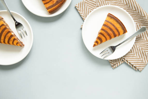 istock Marble cake (zebra) on light grey background. Pieces on white plates. 1251685744