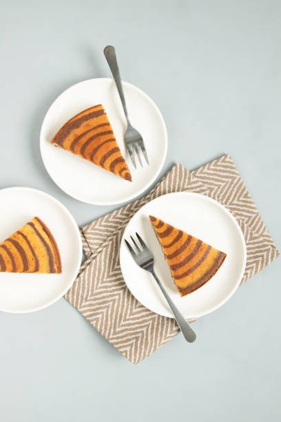 istock Marble cake (zebra) on light grey background. Pieces on white plates. 1251685773
