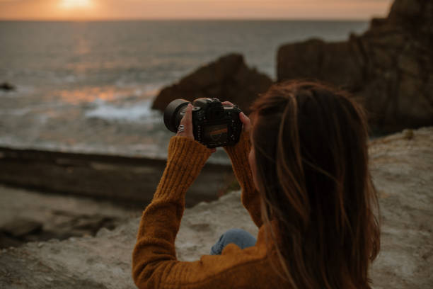 istock Young woman using a DSLR camera at sunset 1251687960