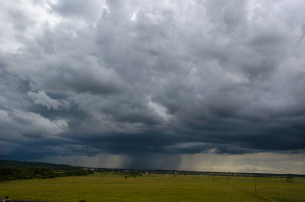 istock Curly cloud drops rain on the green meadow 1251688006
