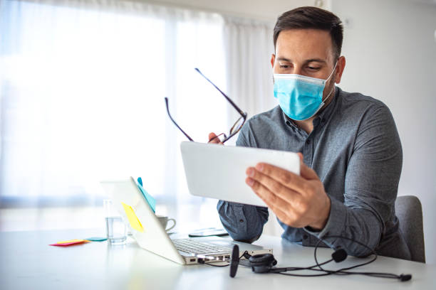 Man surfing the internet wearing a facemask.