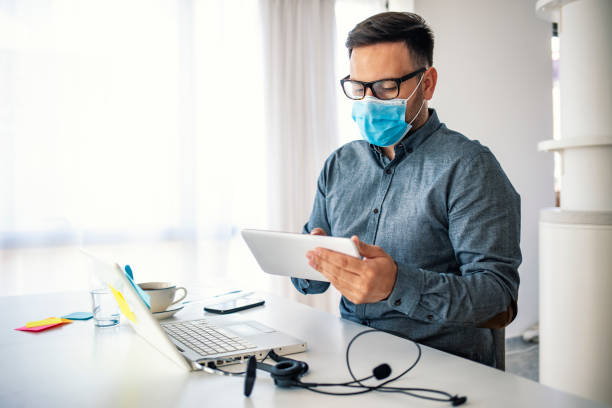 istock Man in a medical mask at the office. 1251688159