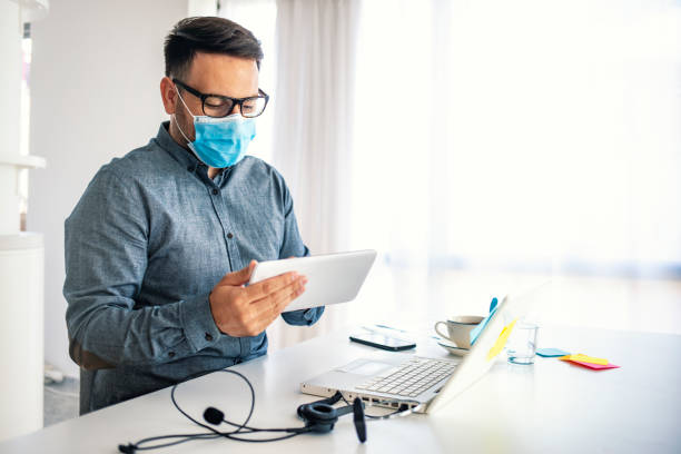 istock Man in a medical mask at the office. 1251688451