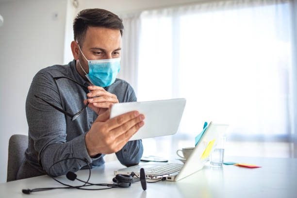 istock Man in a medical mask at the office. 1251688455