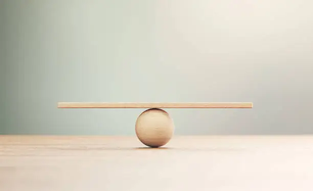 Photo of Wooden Seesaw Scale Sitting on Wood Surface in Front of Defocused Background