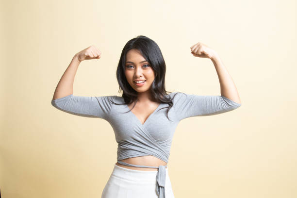istock Beautiful young Asian woman flex bicep. 1251688981