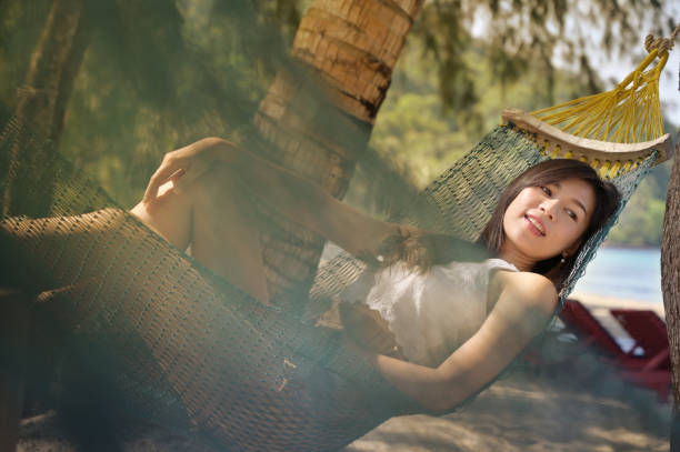 Portrait beautiful young asian woman sitting on hammock beach