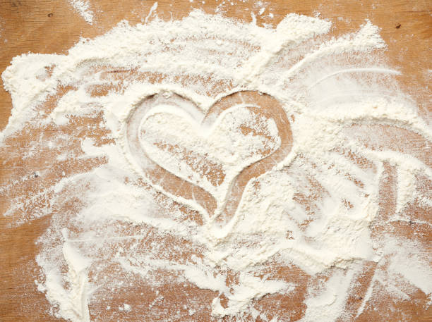 istock sprinkled white wheat flour on a brown wooden background 1251694336