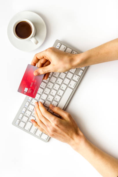 istock shopping online payment. Hand enter data on keyboard on white desk top-down 1251695889