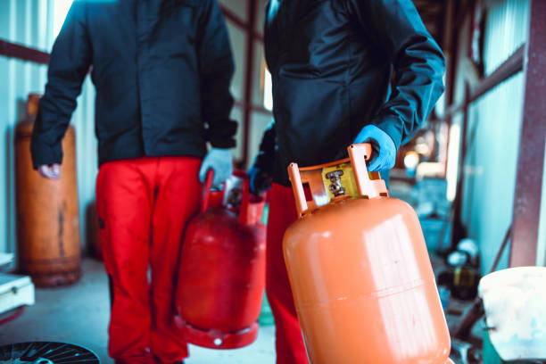 istock Male Workers Taking Gas Cylinders For A Refill 1251697133