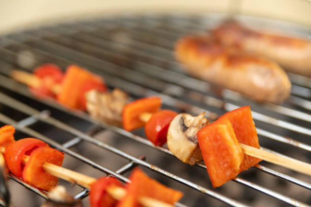 Cooking veg skewers on a BBQ in a back yard