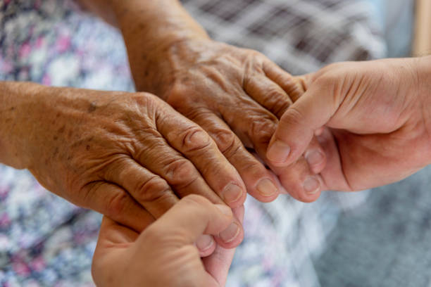 istock Young man holding a senior woman's hand 1251698345