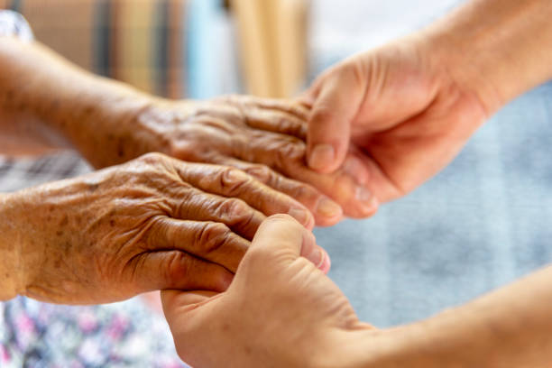 istock Young man holding a senior woman's hand 1251698374