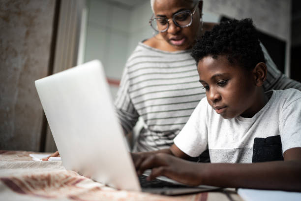 istock Mother helping son studying with laptop on a online class at home 1251698426