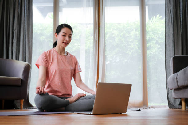 istock woman learning yoga course online. 1251708653