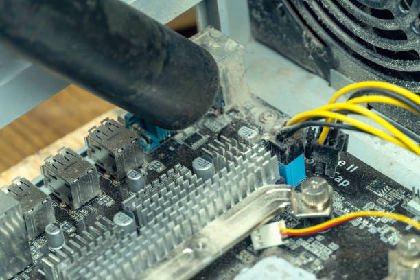 istock master uses a vacuum cleaner to remove dust from the motherboard 1251709377