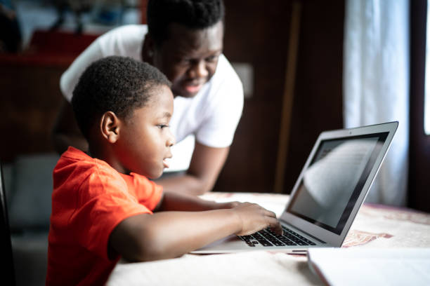 Father and son studying with laptop on a online class at home