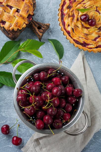 istock Fresh cherry in  iron bowl on a gray concrete background for a pie. Selective focus. Top view. 1251712409