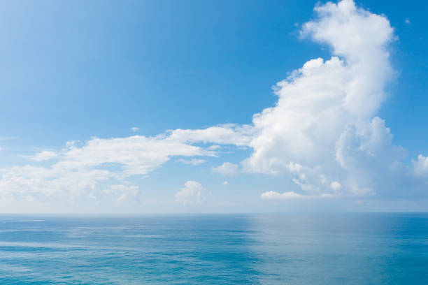 istock Fluffy clouds over the sea horizon 1251714196