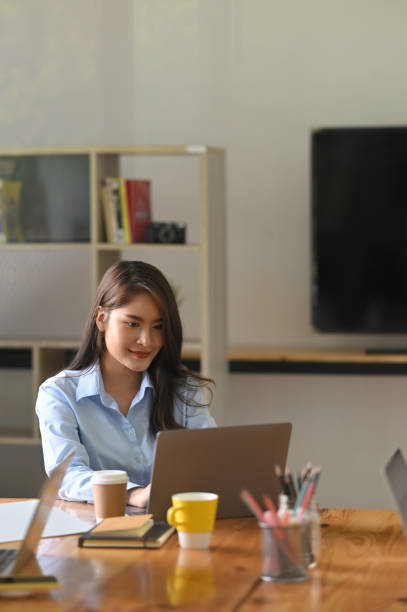 istock A woman is using a computer laptop while sitting at the wooden working desk. 1251716463