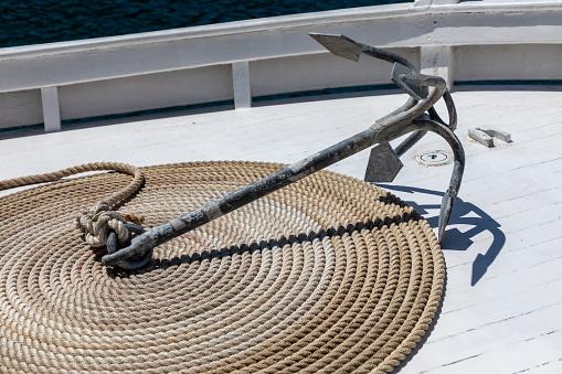 anchor and rope coiled on nautic vessel