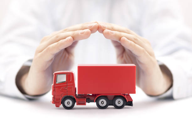 istock Red cargo delivery truck miniature protected by hands 1251717944
