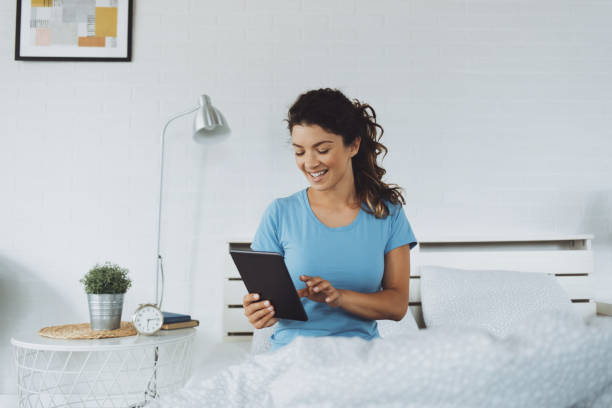 istock Woman using digital tablet in bedroom 1251718322