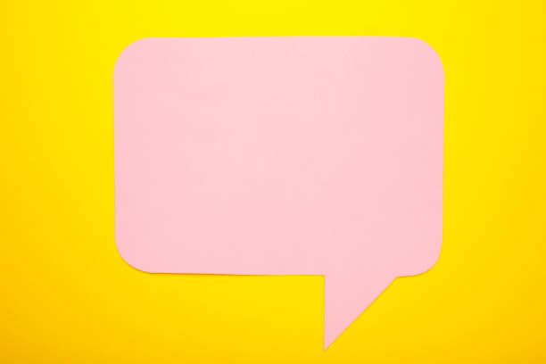 istock Pink paper speech bubbles on yellow background 1251719601