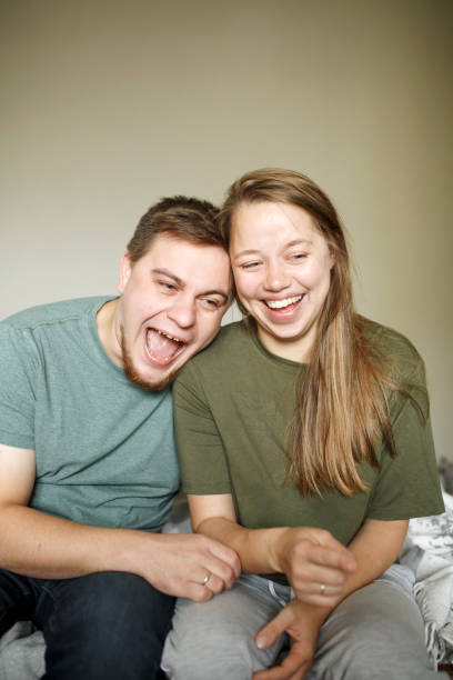 istock Funny laughing young couple sitting at home together 1251719953