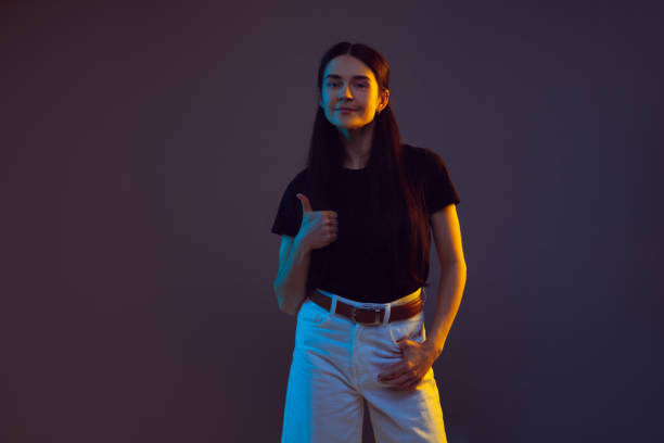 istock Caucasian young woman's portrait on dark background in neon light 1251721292