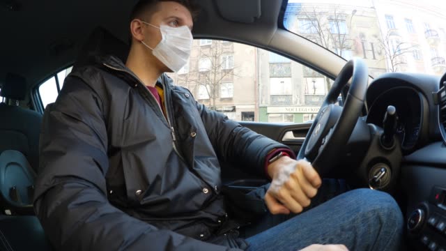 Man Drive Car Wearing Medical Face Mask To Protect From Infection Of Viruses, Pandemic, Air Pollution, Hazardous Particles. Threat Of Coronavirus