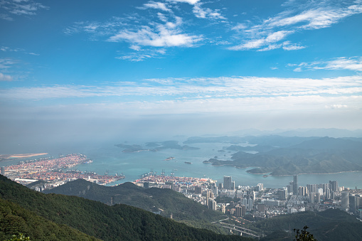 Panorama view of Shenzhen cityscape in direction of Yantian district and Hongkong island from top of Wutong Mountain on a sunny day, Guangdong, China