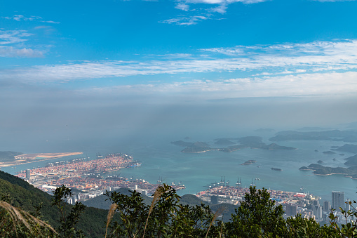 Panorama view of Shenzhen cityscape in direction of Yantian district and Hongkong island from top of Wutong Mountain on a sunny summer day, Guangdong, China