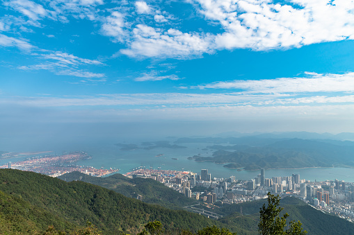 Panorama view of Shenzhen cityscape in direction of Yantian district and Hongkong island from top of Wutong Mountain on a sunny summer day, Guangdong, China