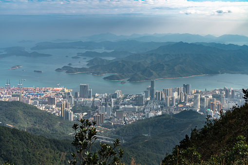 Panorama view of Shenzhen cityscape in direction of Yantian district and Hongkong island from top of Wutong Mountain on a sunny summer day, Guangdong, China