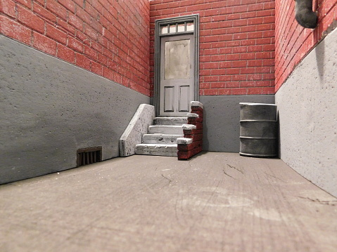 1:12 scale diorama of back alley entrance.  Brick wall and stairs.
