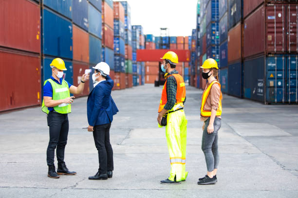 istock Temperature measurement with employee temperature meter before entering work at container yard 1251729457