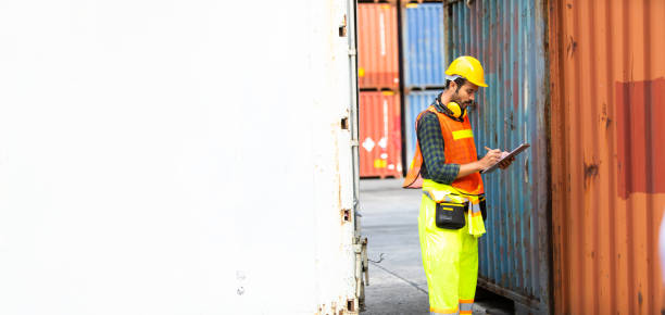 istock supervisor inspects wearing hardhat safety helmet working and checking control container shipping terminal at  shipping port 1251729475