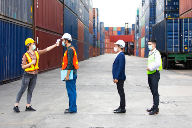istock Temperature measurement with employee temperature meter before entering work at container yard 1251729478