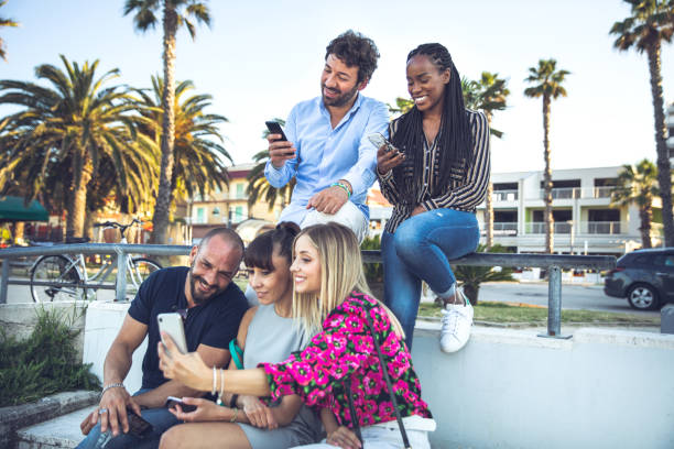 istock Group of multicultural friends using smartphone 1251730086