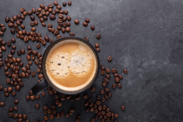 istock Cups of coffee and coffee beans on dark stone background. Top view. Copy space 1251731504