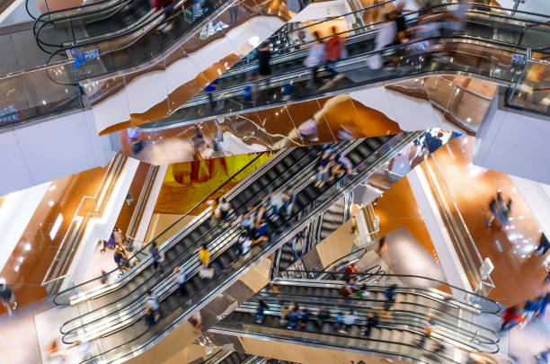 les gens sur de nombreux escalators en mouvement rapide dans le grand centre commercial moderne. concept de consommation clients clients se déplaçant sur les escaliers d’escalator - escalator photos et images de collection